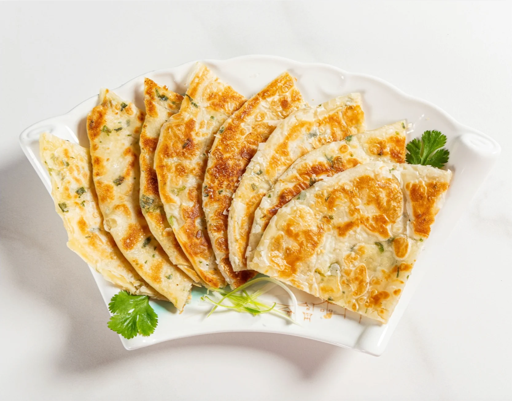 Crispy Chinese scallion pancakes served on a decorative plate