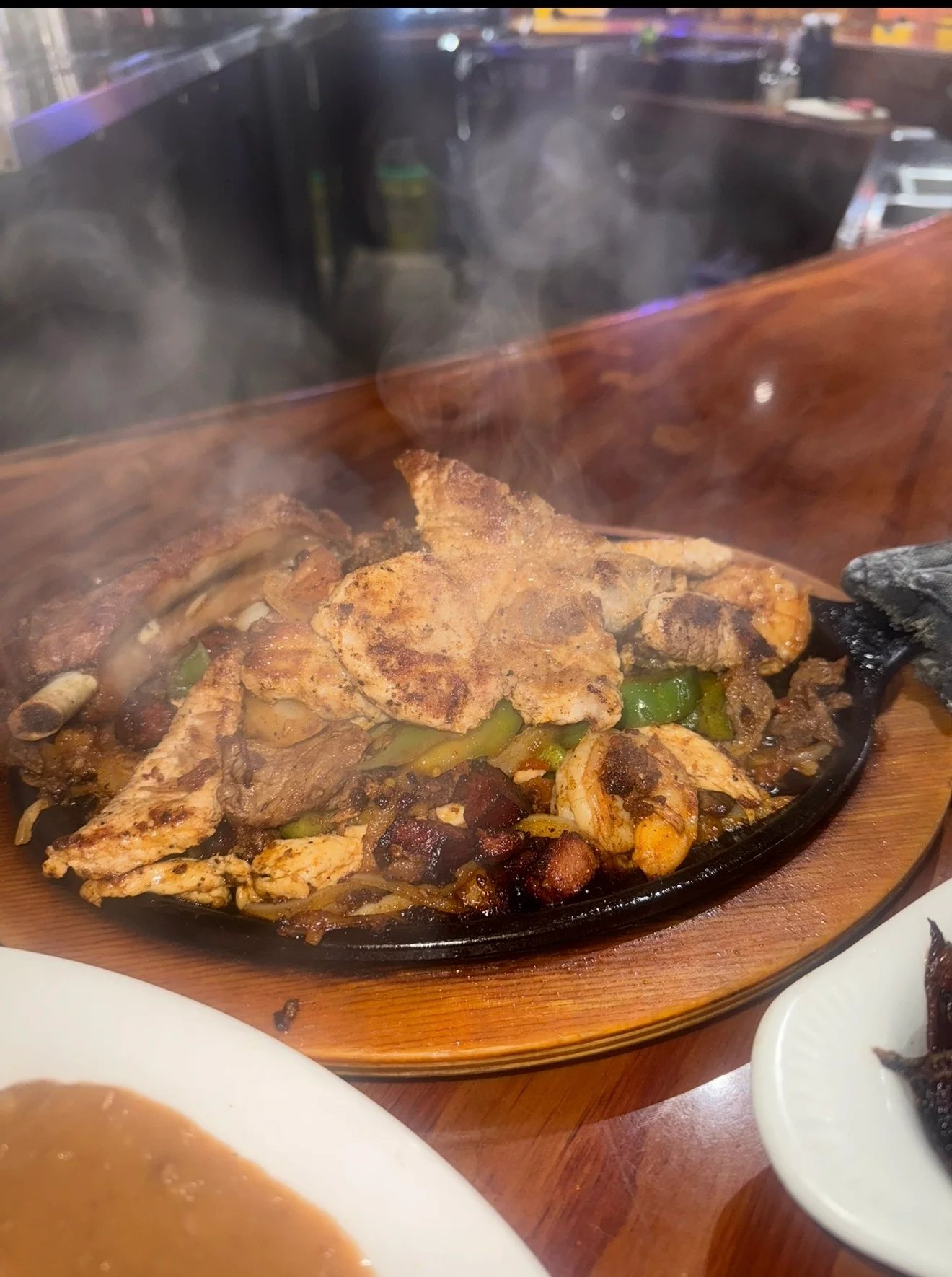 Sizzling fajitas with chicken and shrimp served on a hot skillet