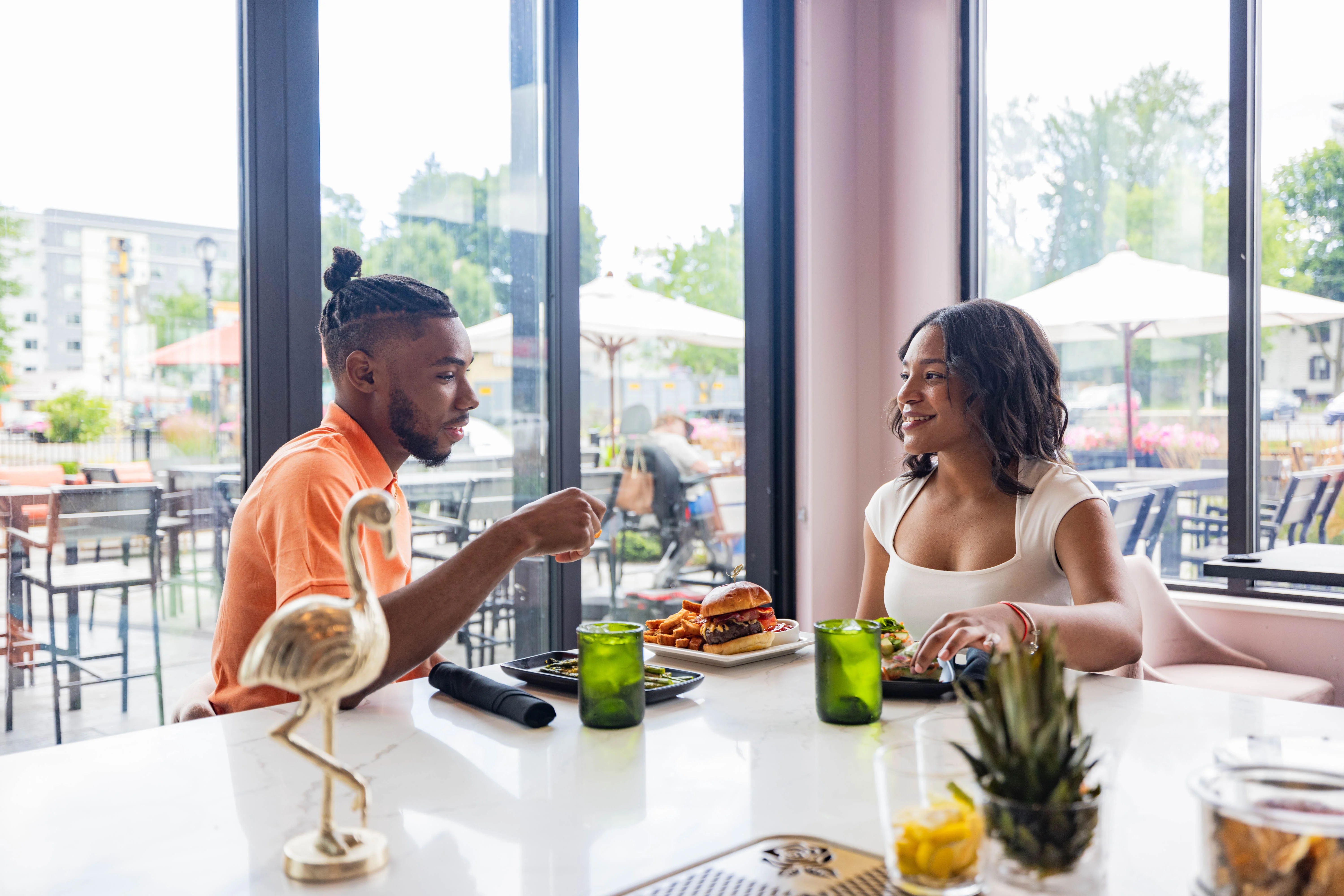 Couple enjoying burgers and drinks in a modern restaurant setting
