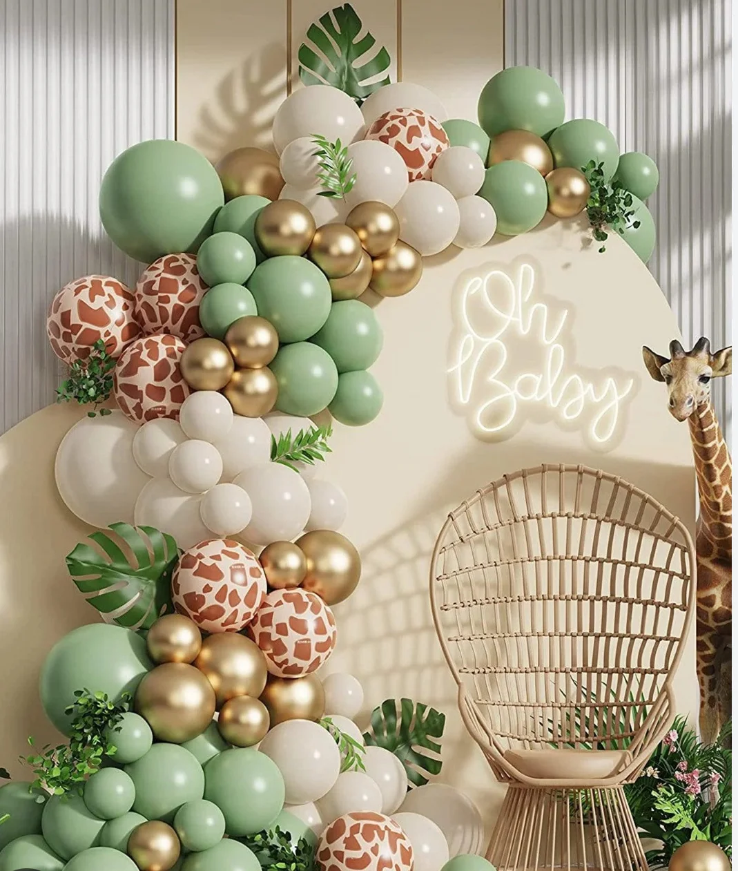 A colorful decorative setup featuring a variety of balloons, including green, gold, and patterned designs, with a rattan chair and a giraffe figurine in the background.