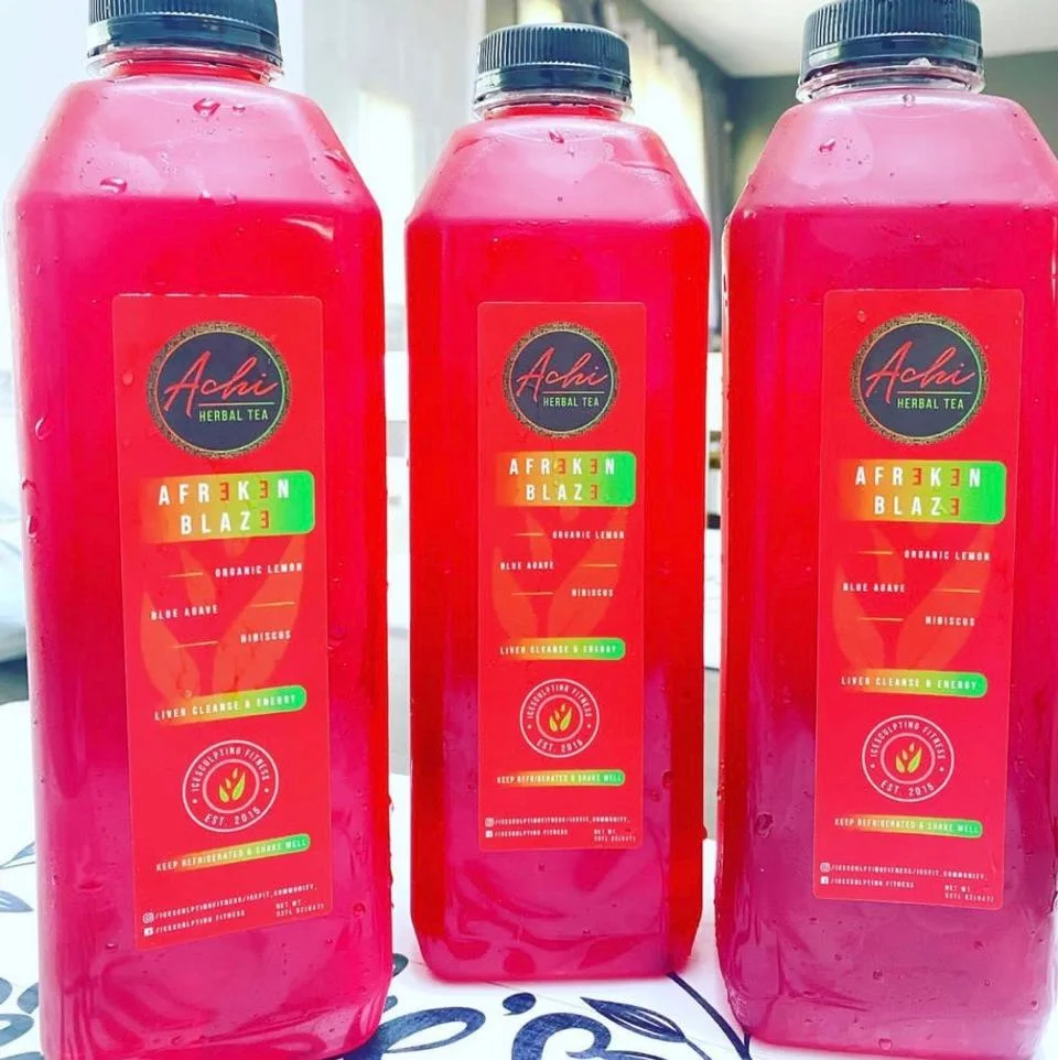 Three bottles of herbal tea, vibrant red in color, labeled with the brand name and drink information. Each bottle features a refreshing design.