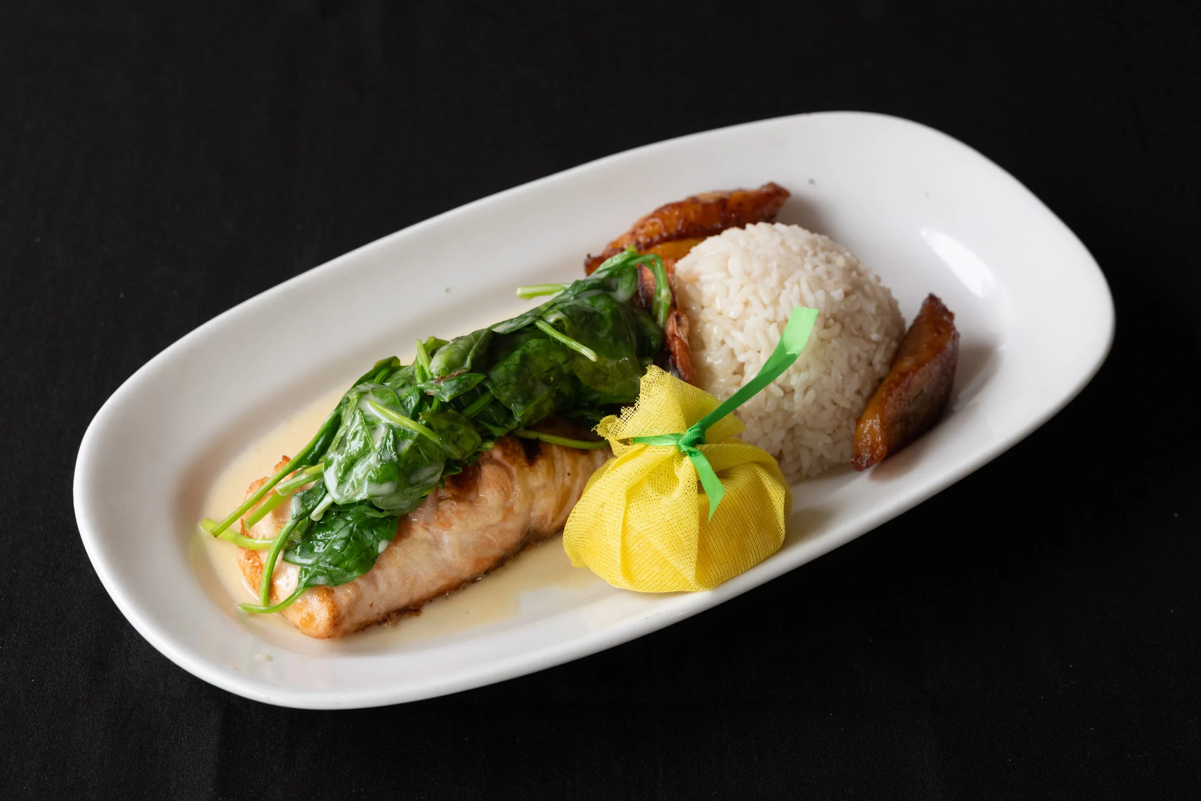 Grilled salmon with spinach and rice, a Caribbean-inspired dish