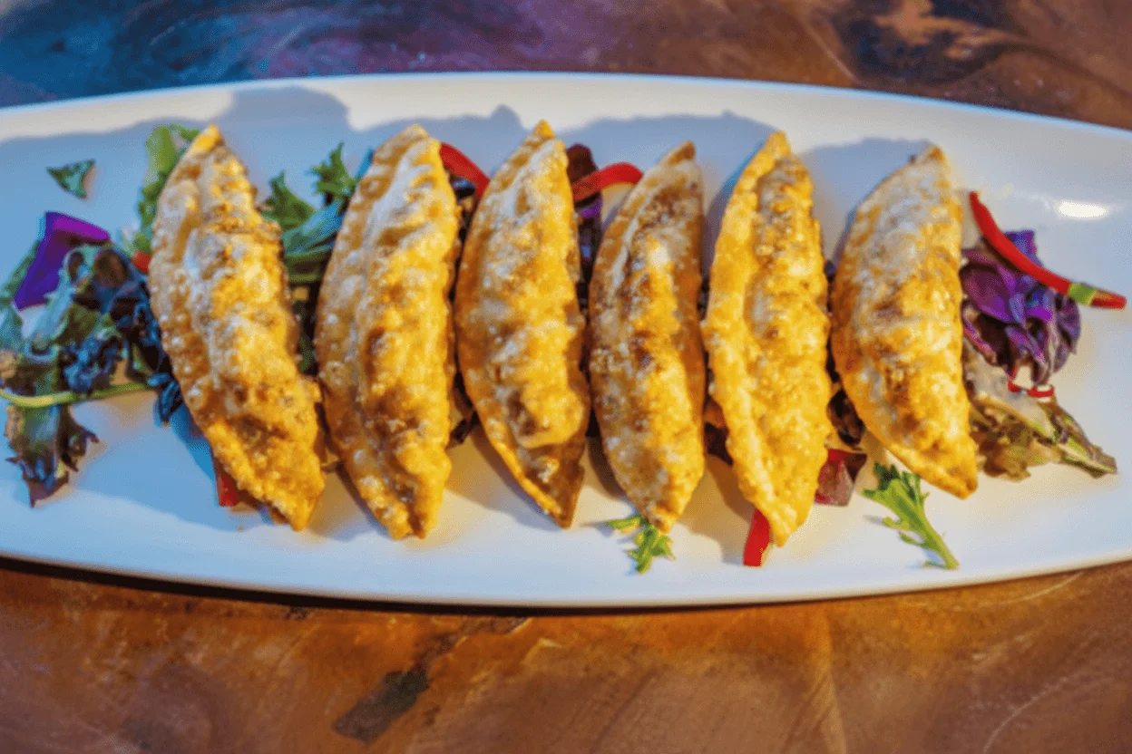 Crispy Japanese gyoza served on a bed of greens