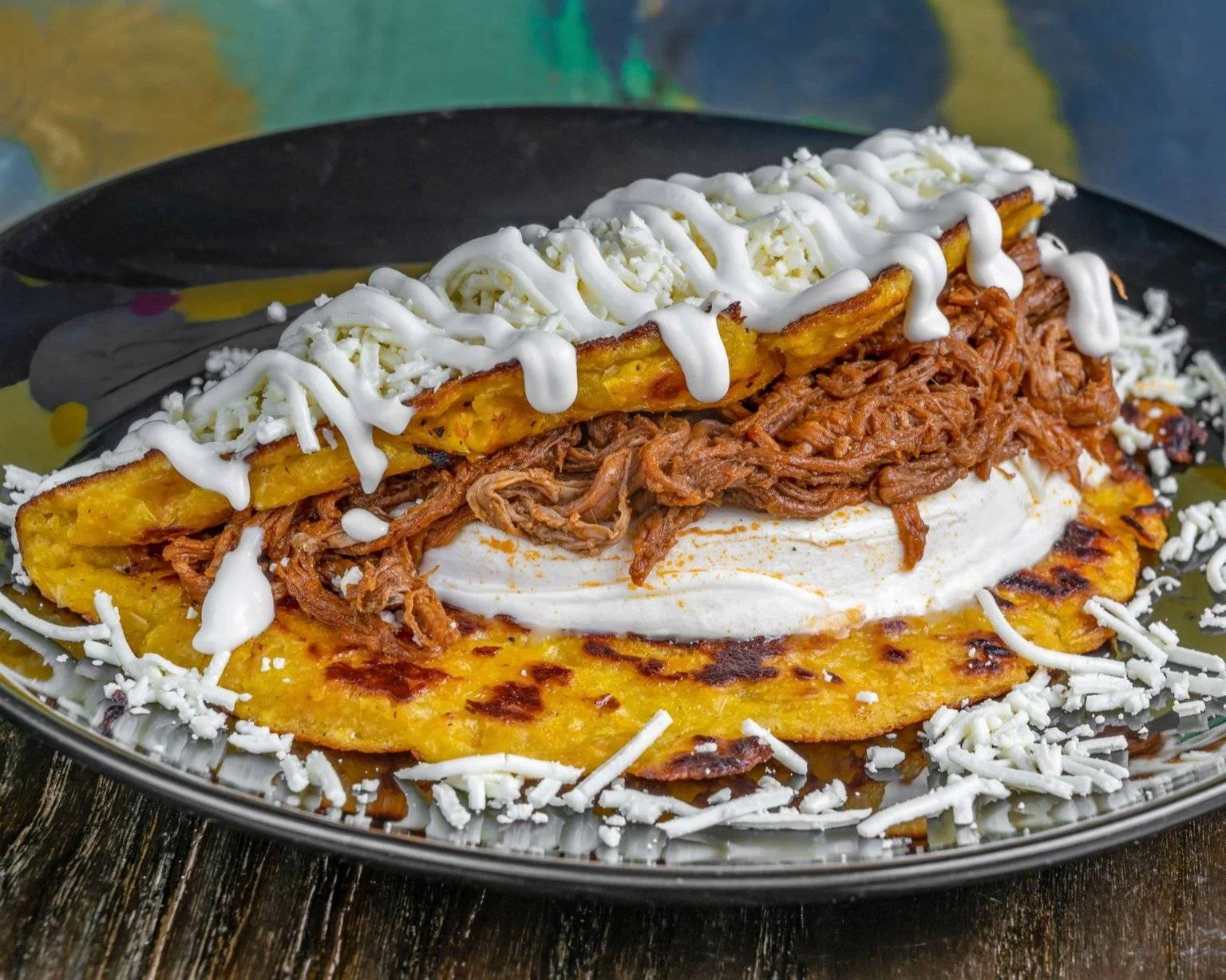 Delicious Mexican tlayuda topped with shredded beef and cream