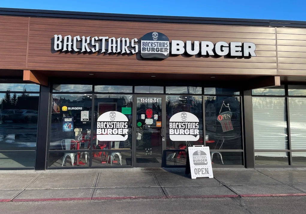 Exterior view of Backstairs Burger restaurant with open sign.