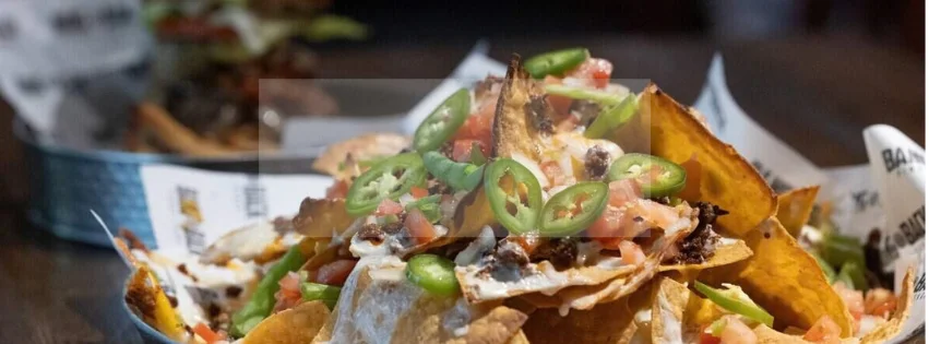 Loaded nachos with jalapeños, salsa, cheese, and pulled meat