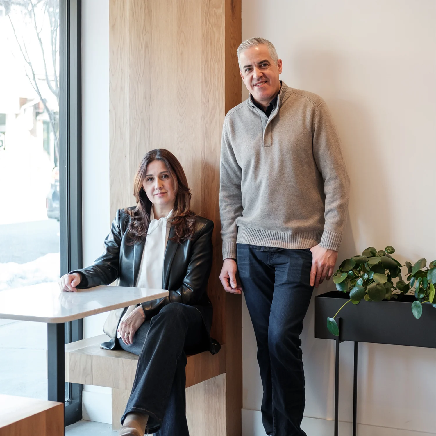 Cozy restaurant interior with two people posing by a window