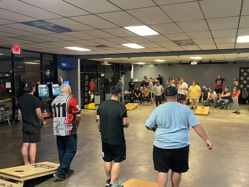 Lively restaurant event with guests playing cornhole indoors