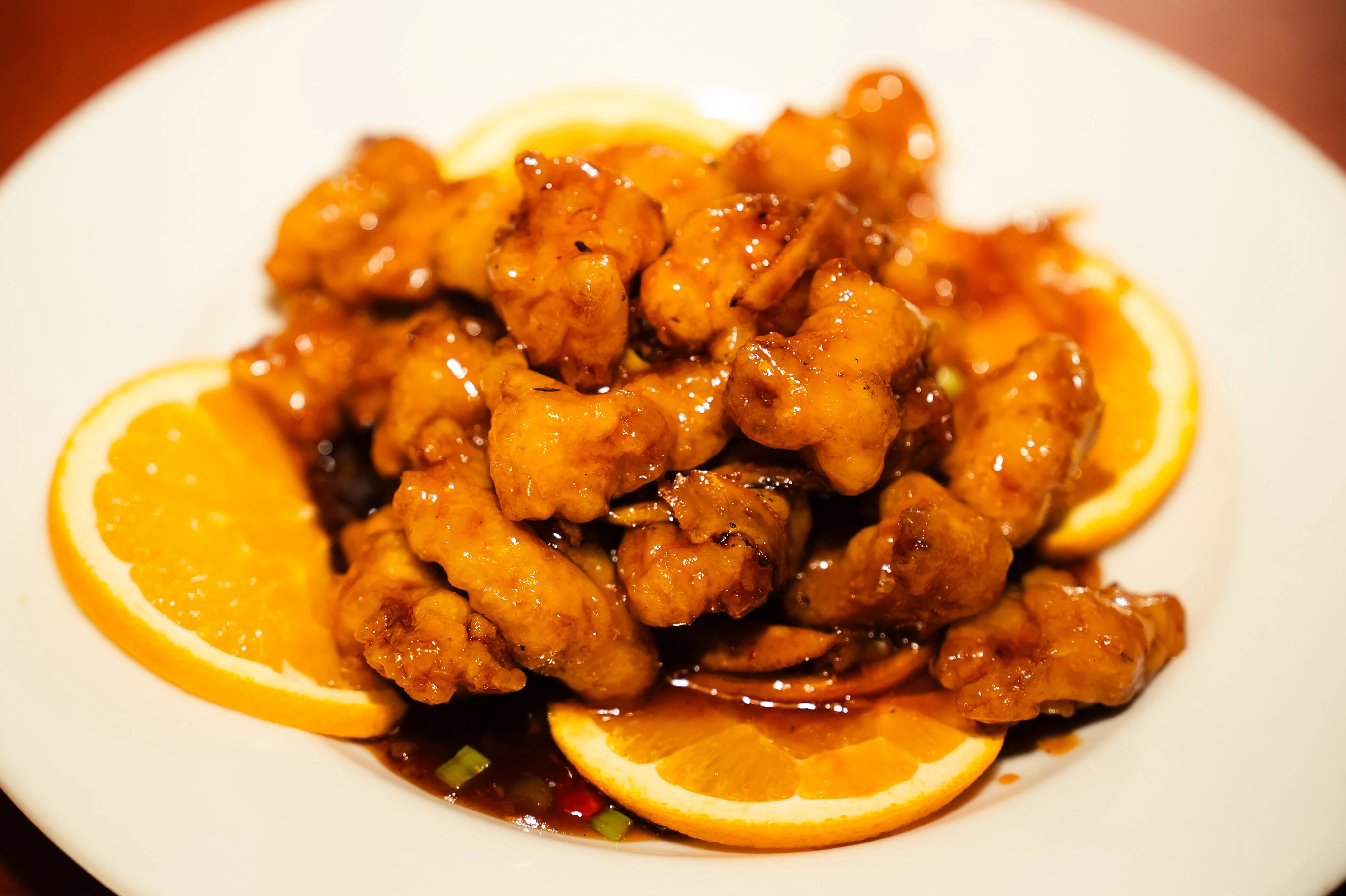 Crispy orange chicken served with citrus slices