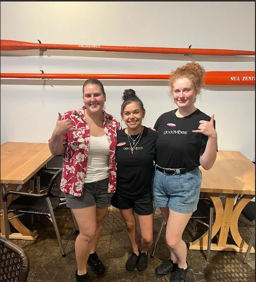 Three restaurant staff members posing together with friendly smiles
