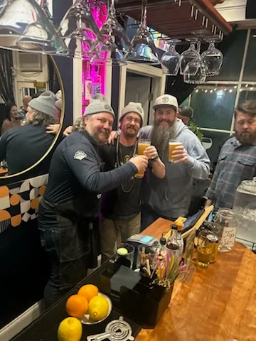 Bartenders celebrating with drinks at a lively bar