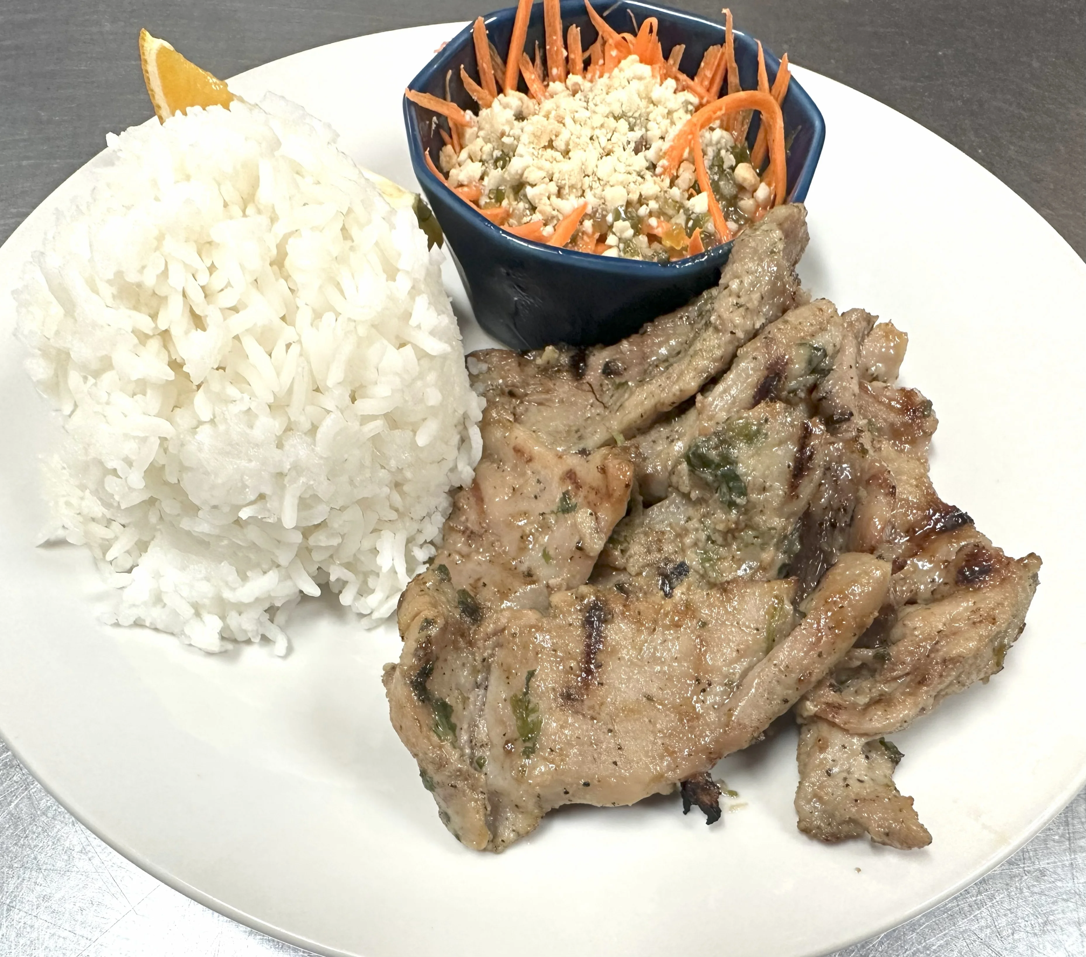Grilled pork chops with rice and carrot salad, a Southeast Asian delight