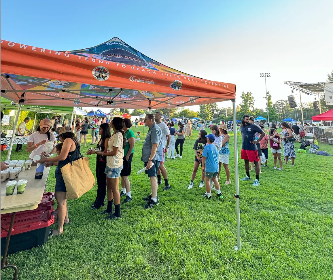Community event with people in line at a food tent