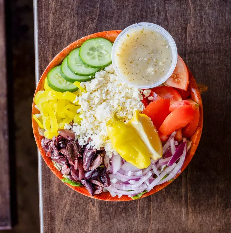 Delicious city pie with a variety of toppings on a wooden table.