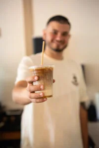 Barista presenting a refreshing iced coffee drink