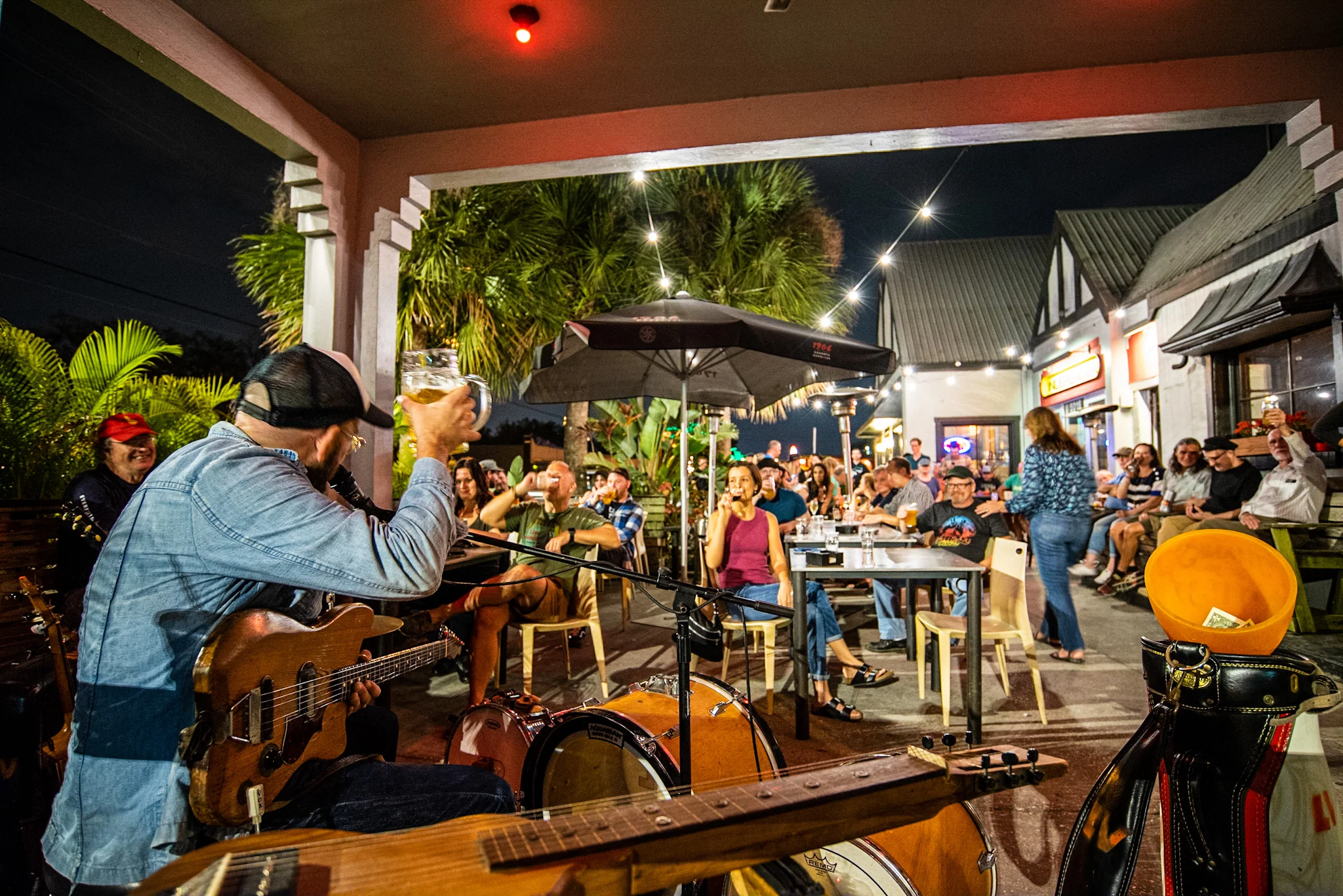 Live music performance at a vibrant outdoor restaurant with a lively crowd.