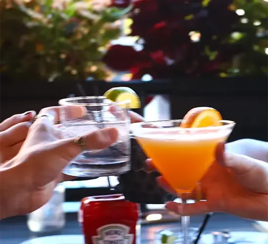 Cheers with cocktails and drinks at a lively restaurant setting
