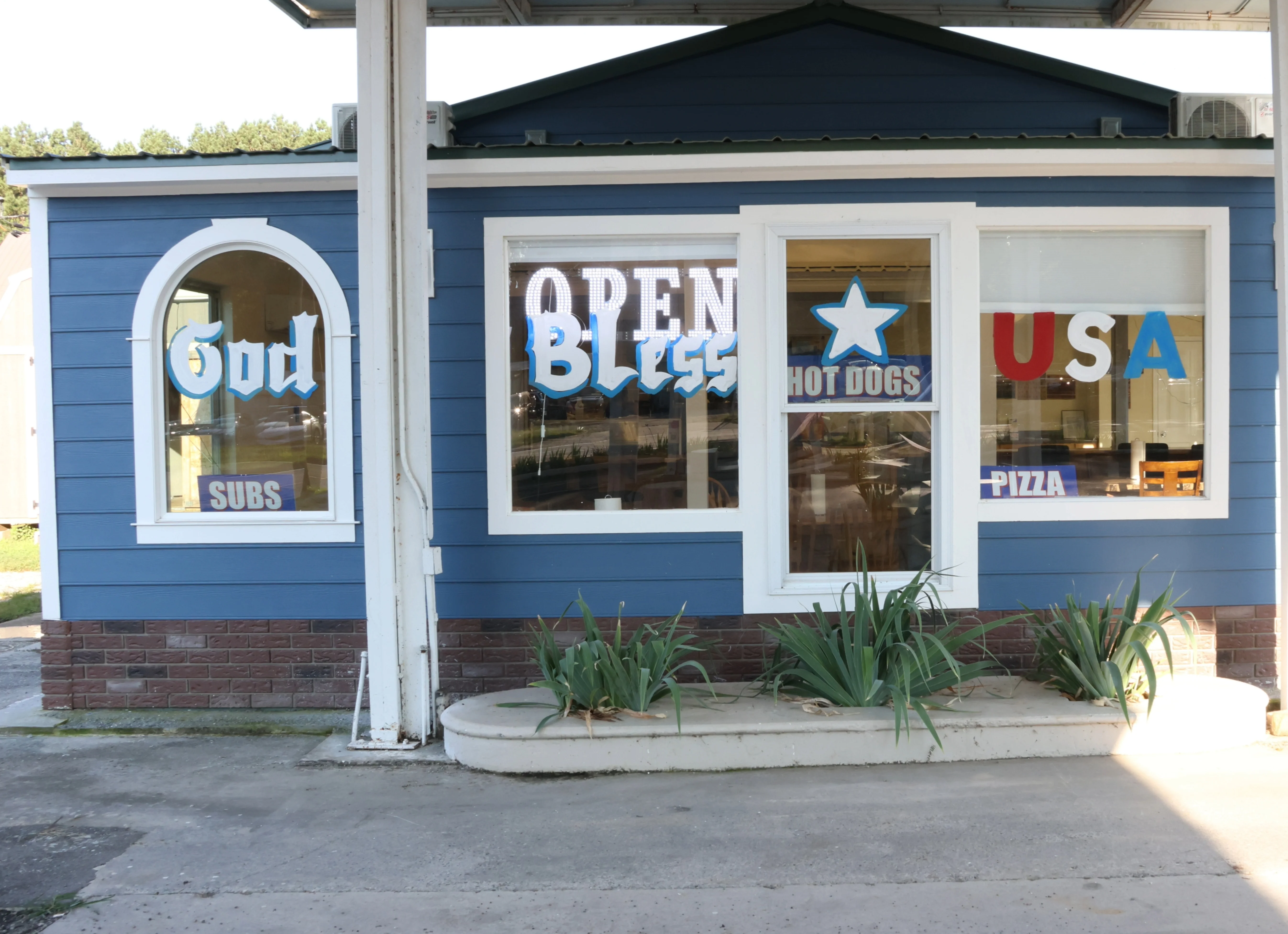 Colorful restaurant exterior with signs for pizza and hot dogs