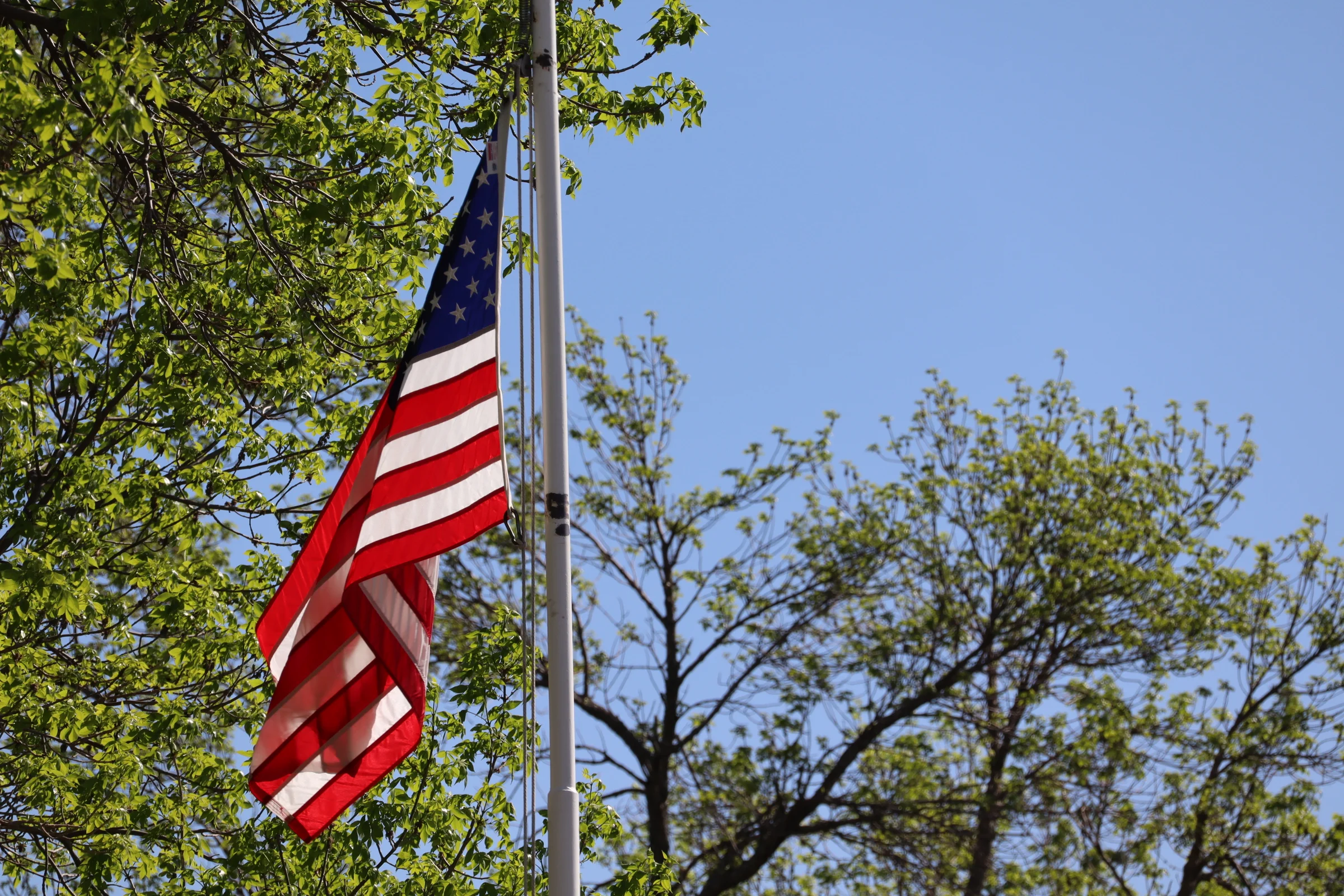 American flag waving against a clear blue sky