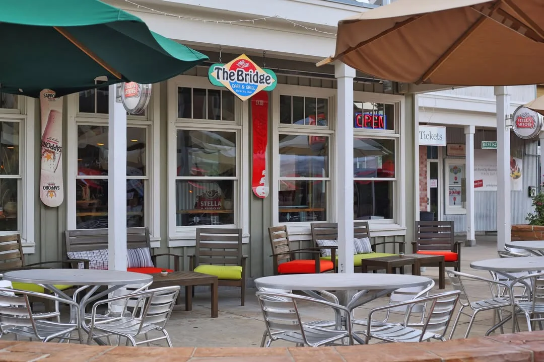 An inviting exterior view of a cafe and grill with outdoor seating and a welcoming atmosphere.