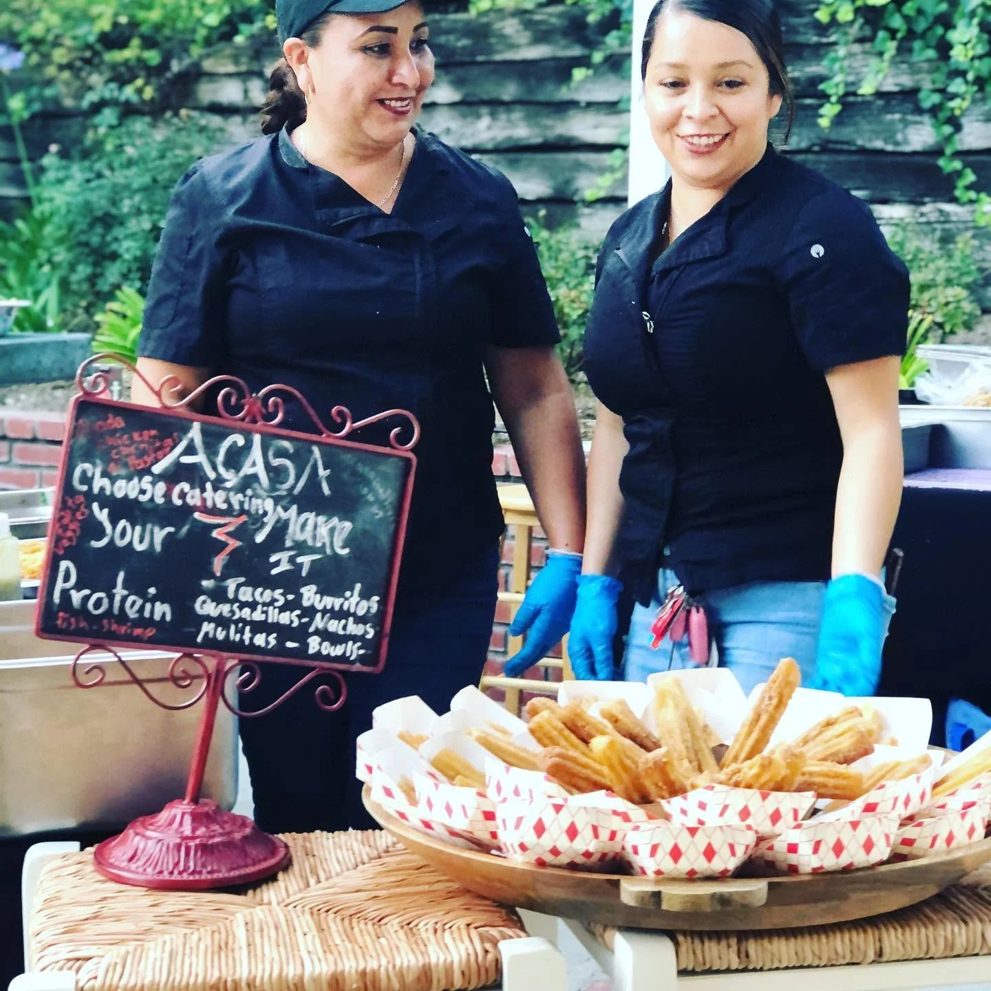 Churros served at a catering event with smiling staff