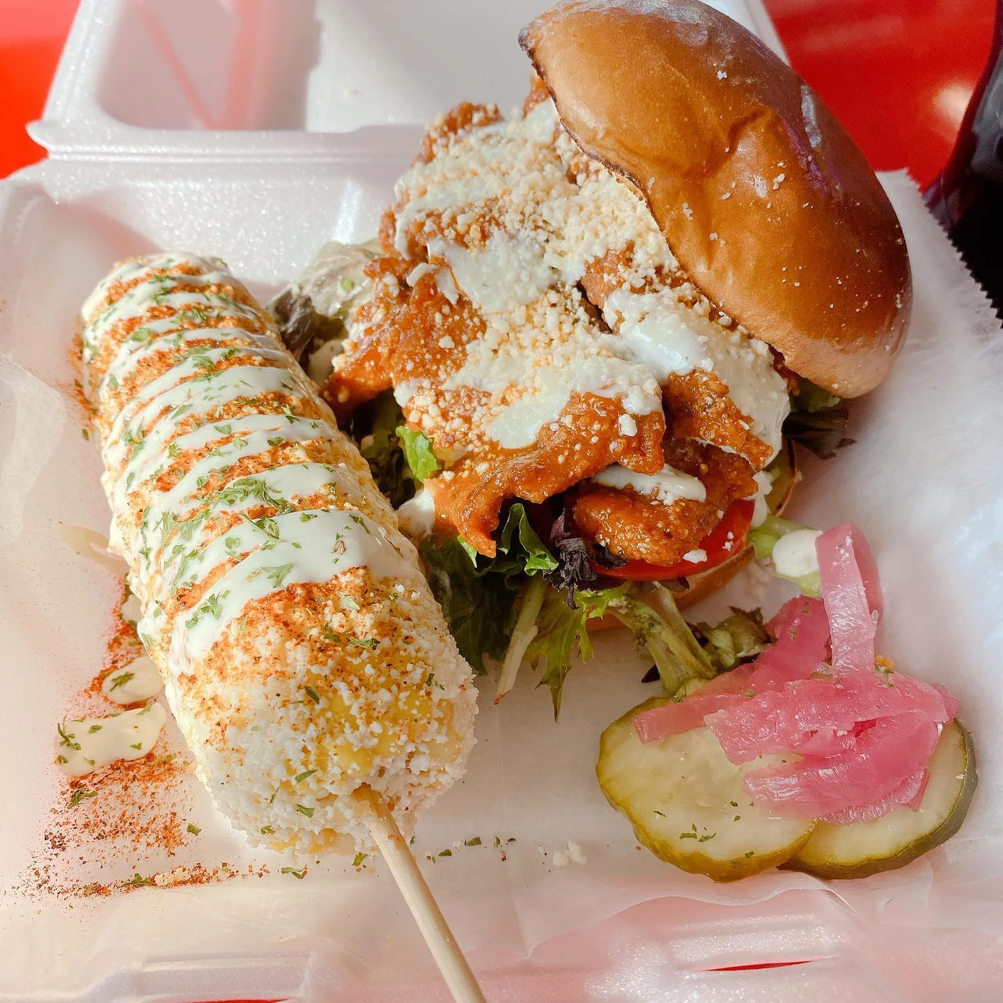 Crispy chicken sandwich with elote and pickled onions