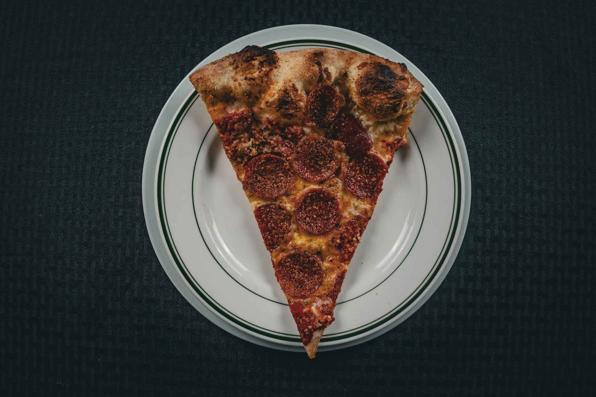 Slice of pepperoni pizza on a classic white plate