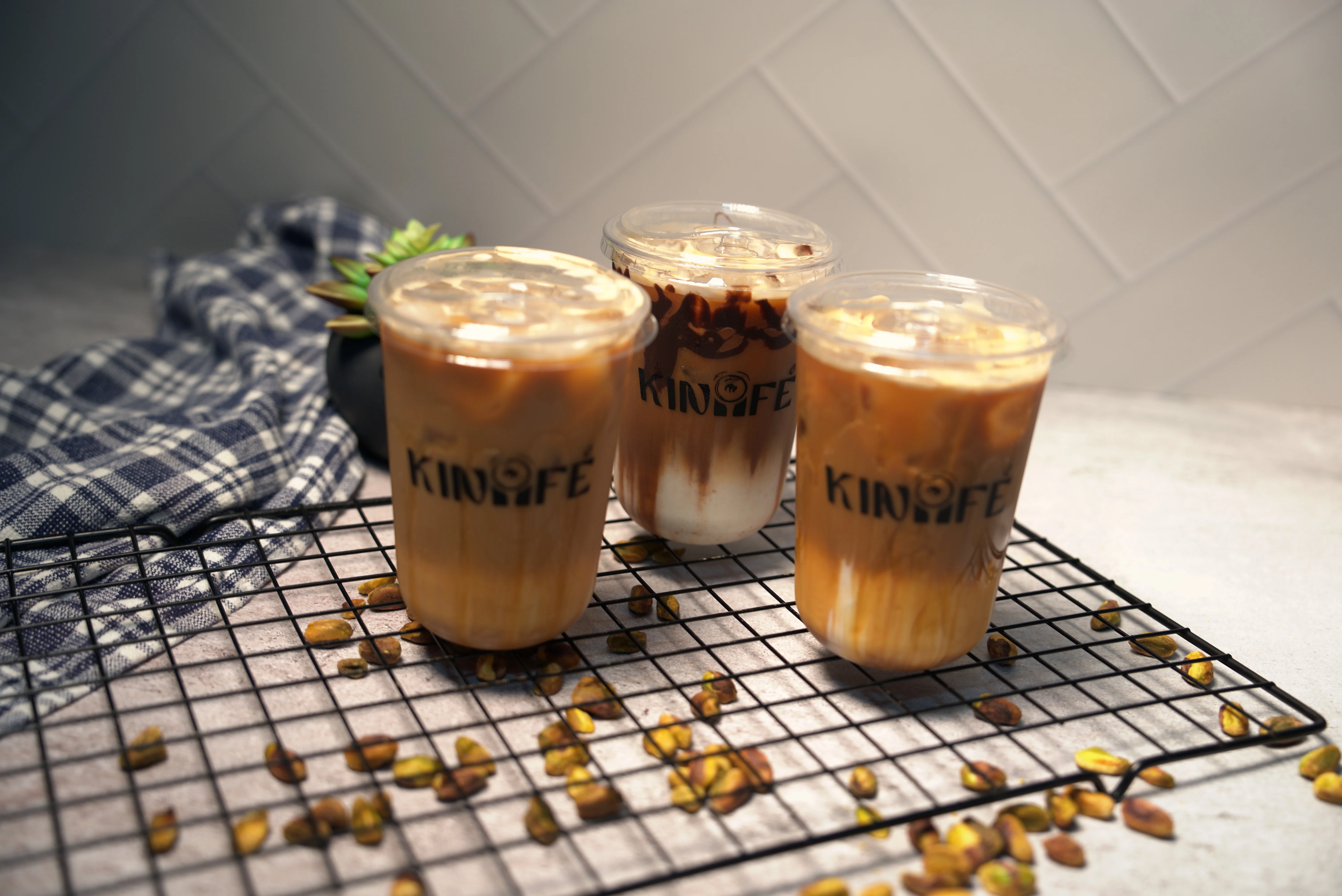 A variety of iced coffee drinks displayed in clear cups, showcasing different layers of milk and flavored syrups.