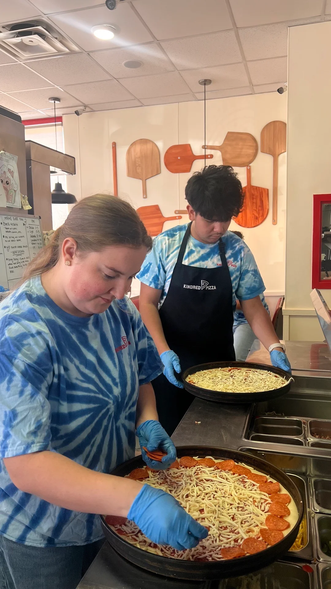 Pizza preparation with pepperoni and cheese at a pizzeria