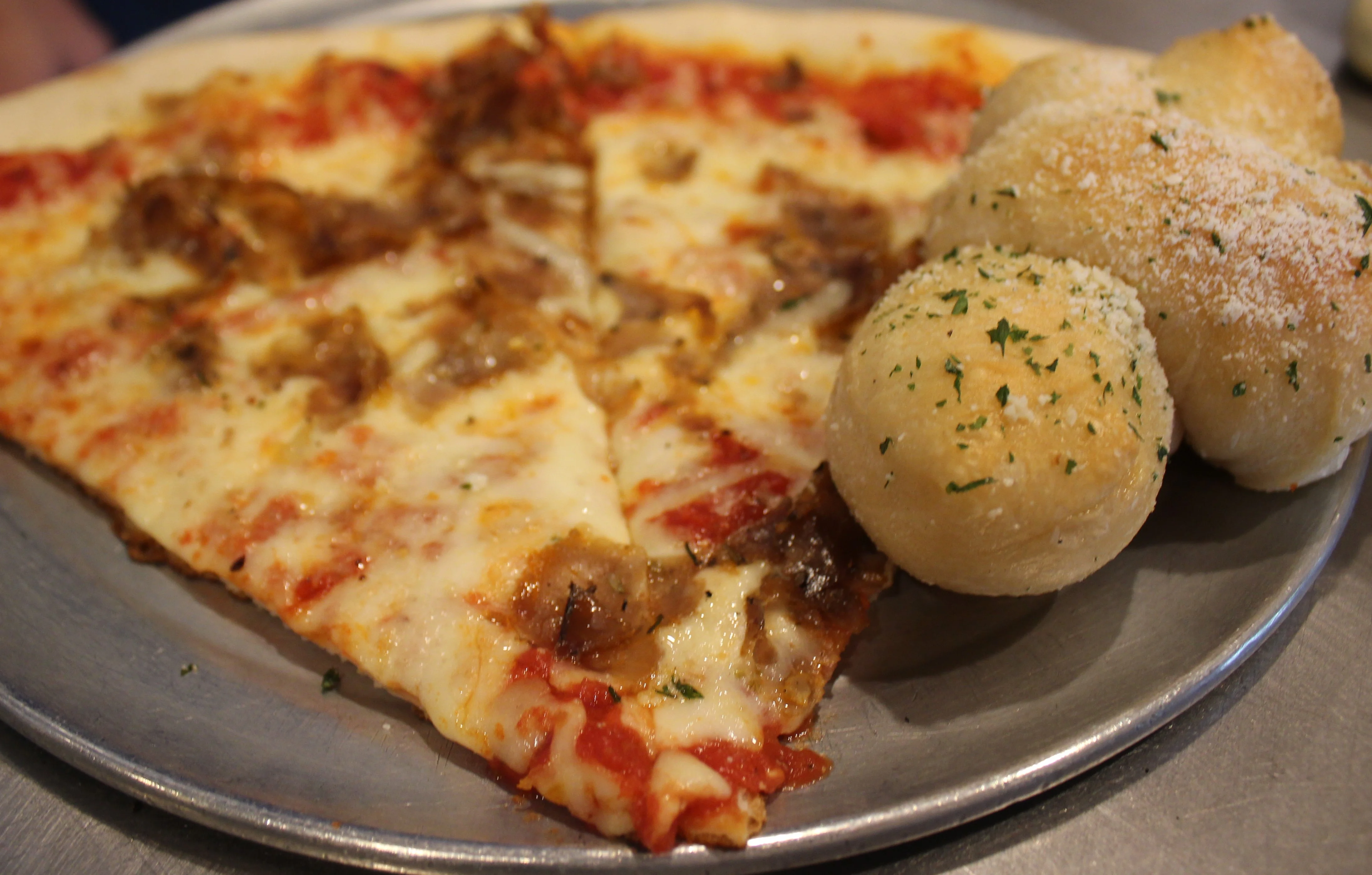 Slice of meat lover's pizza with cheesy garlic knots