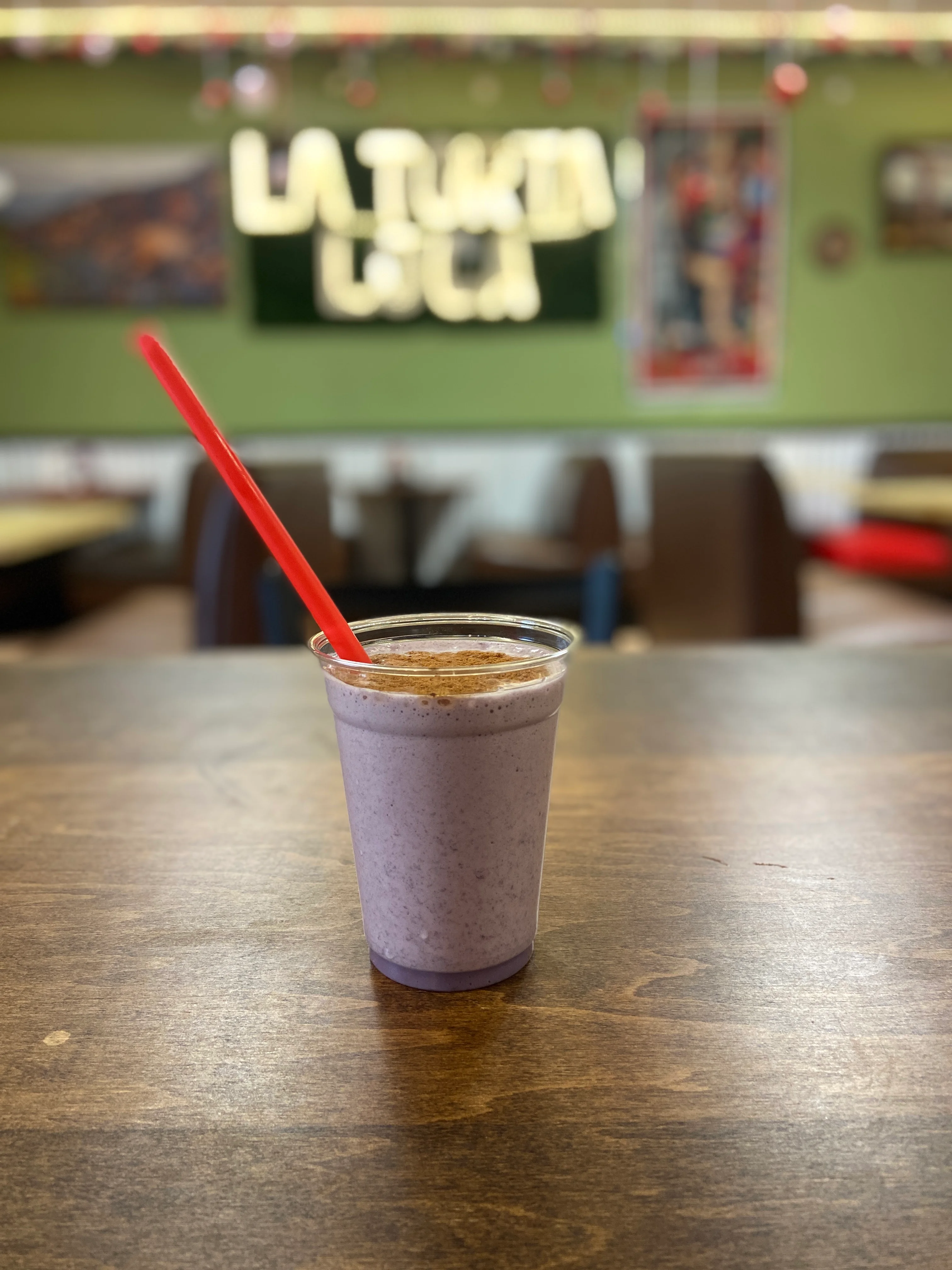 Refreshing berry smoothie in a clear cup with a red straw