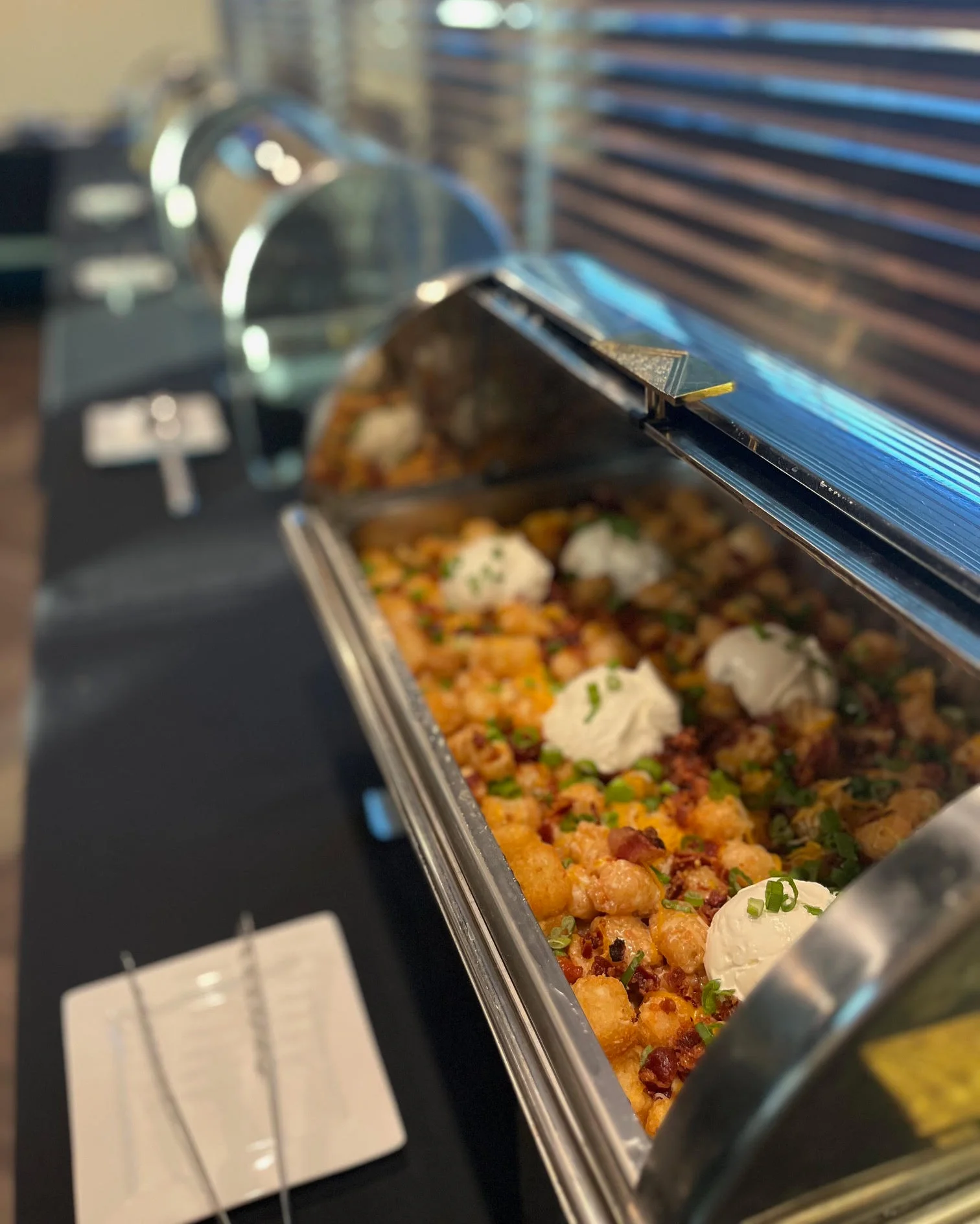Loaded tater tots with toppings in a buffet setting