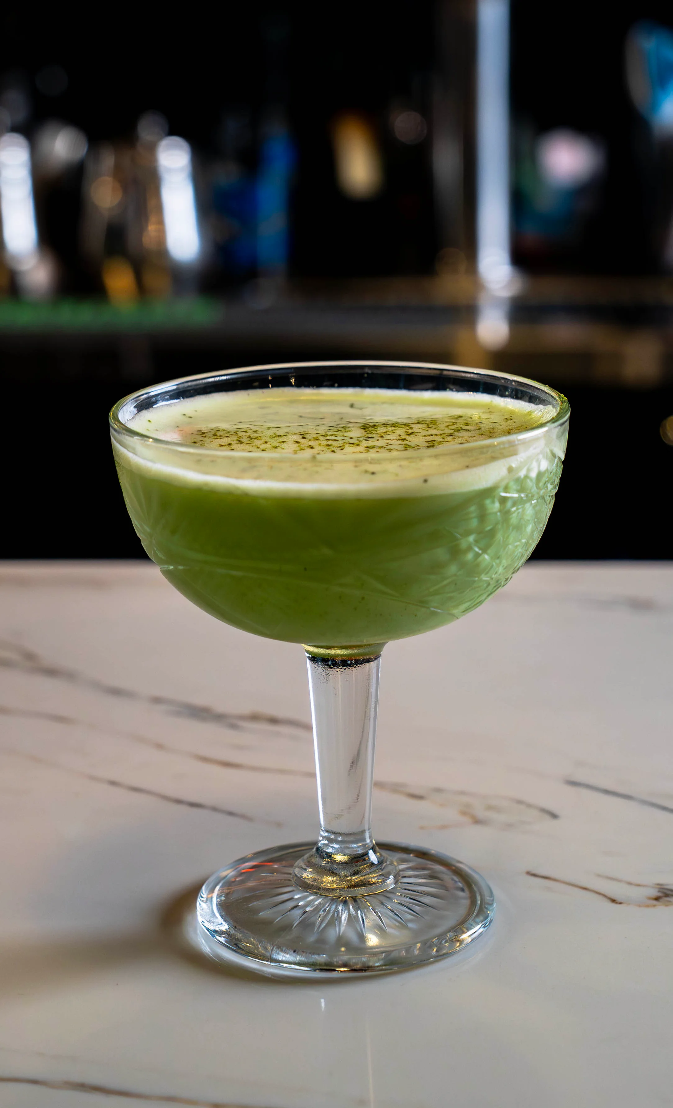 Colorful cocktail served in a glass with garnishes on a wooden table.
