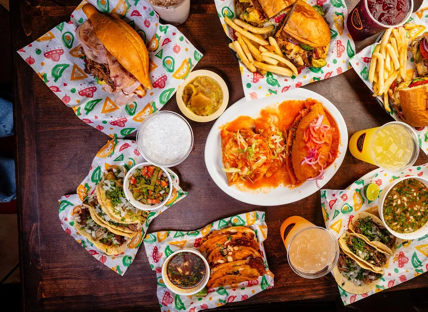 Assorted Mexican tacos and sandwiches on a colorful table