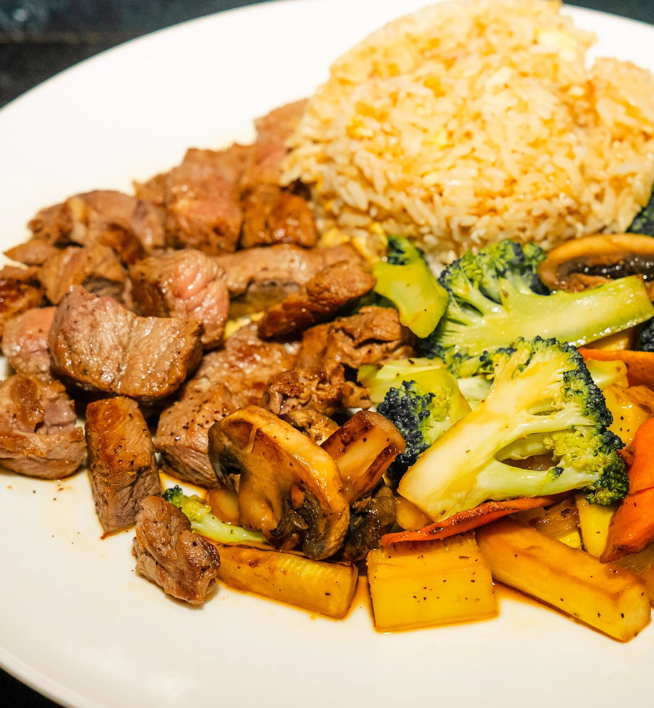 Sizzling hibachi steak with fried rice and mixed vegetables