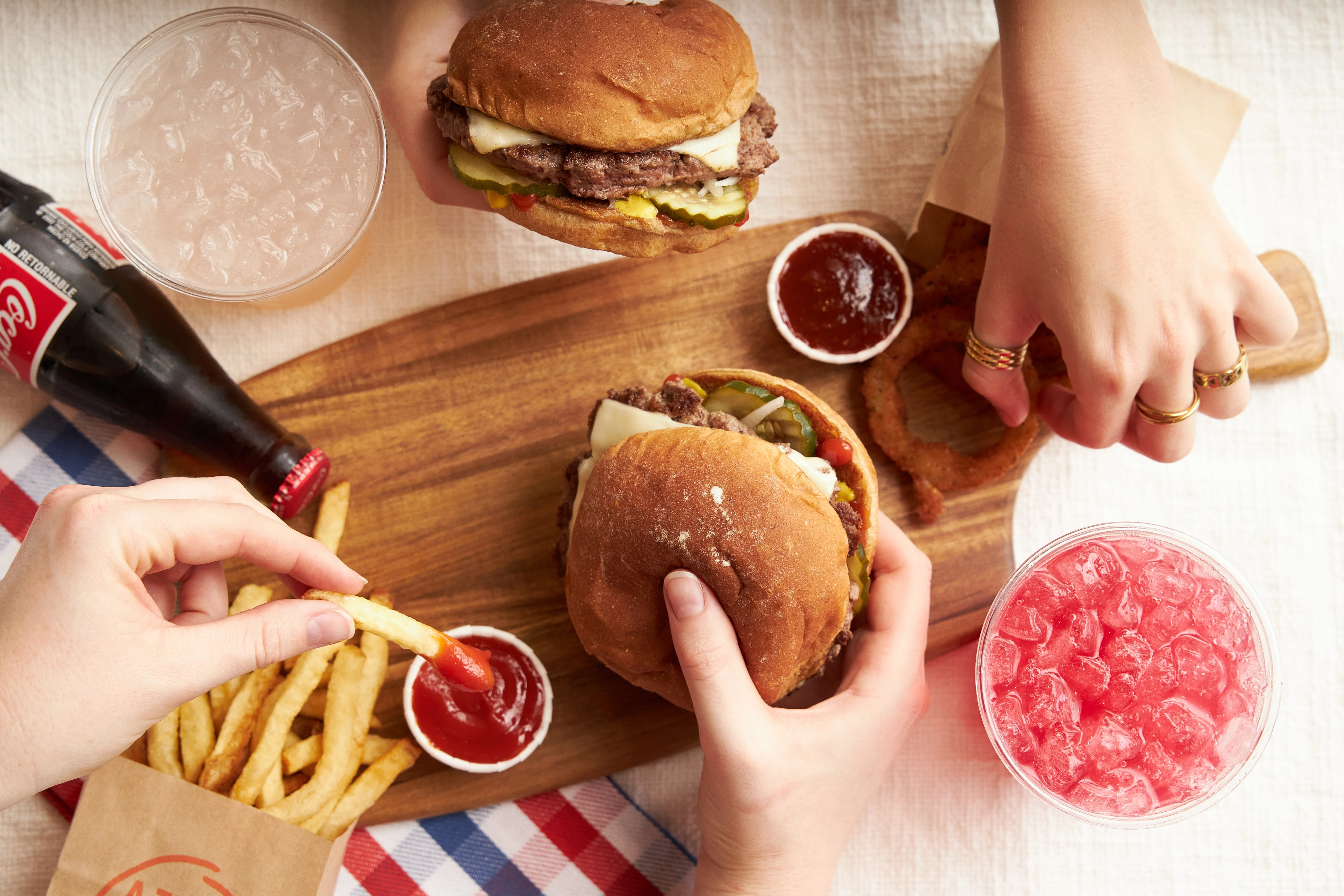 Classic American cheeseburgers with fries and drinks