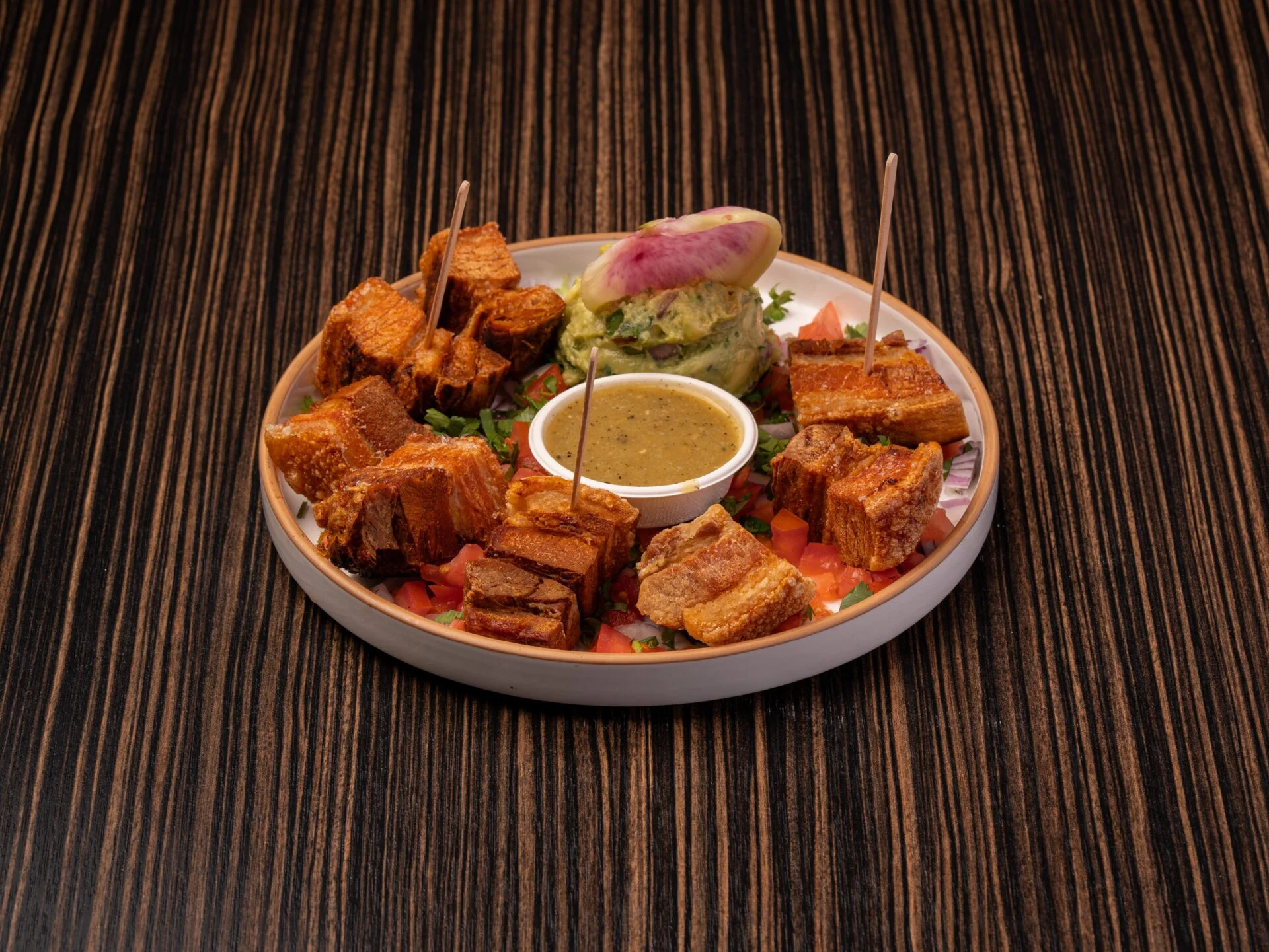 Crispy pork belly served with guacamole and dipping sauce