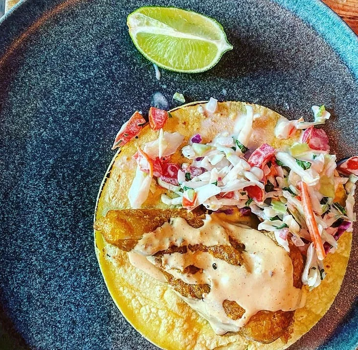 Crispy fish taco with slaw and lime wedge