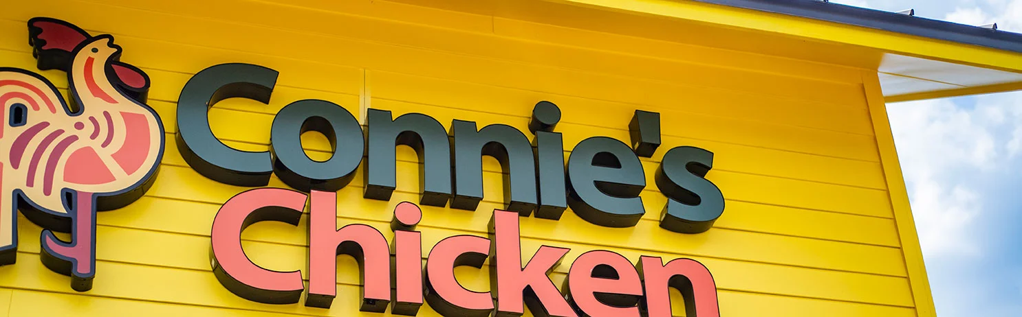 Brightly colored restaurant sign for Connie's Chicken