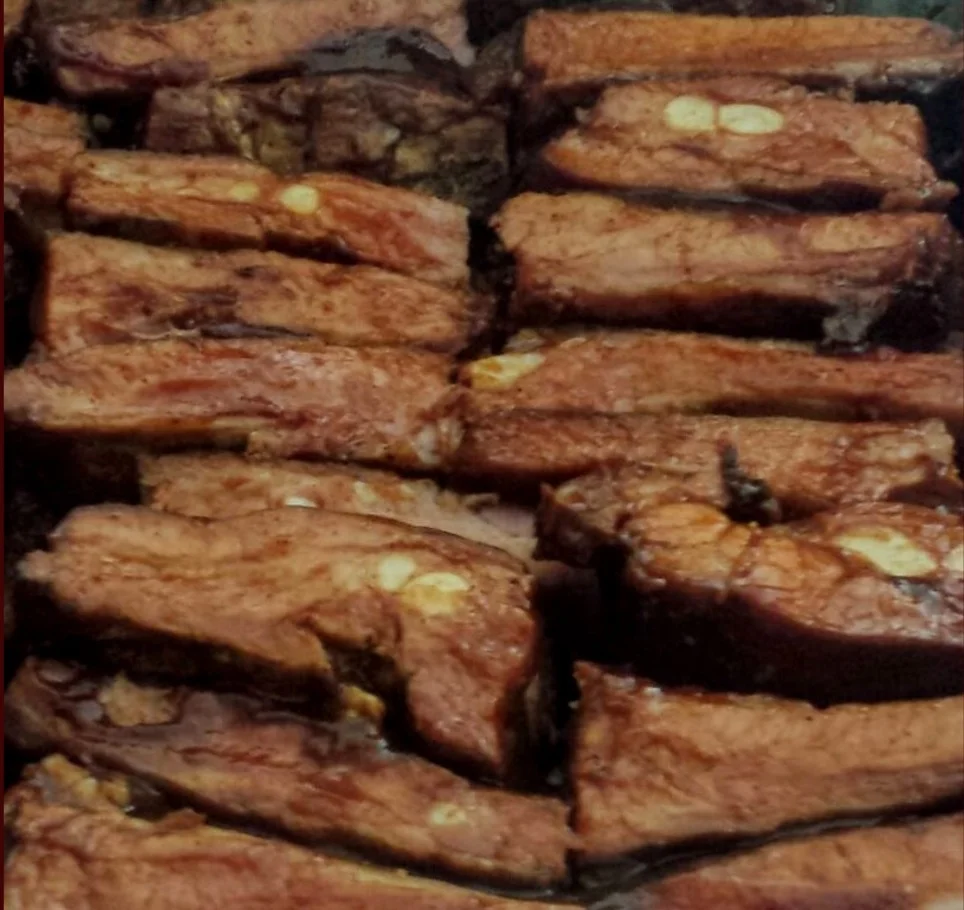 A close-up view of succulent, grilled meat pieces, showing a rich brown color and charred edges.