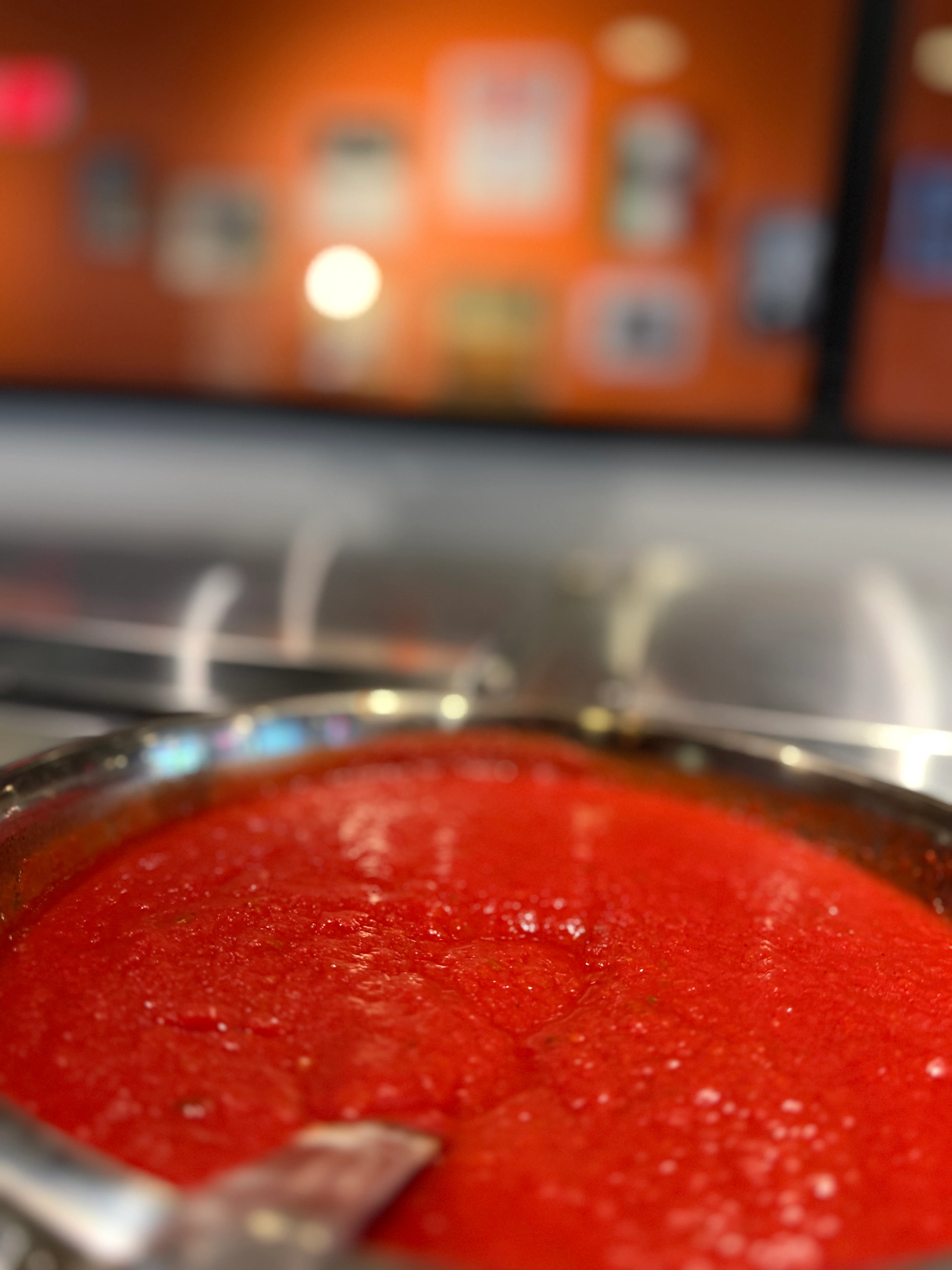 Rich marinara sauce simmering in a restaurant kitchen