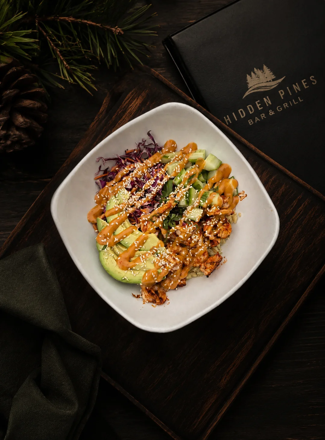 Bowl with avocado, vegetables, and sauce on a wooden board