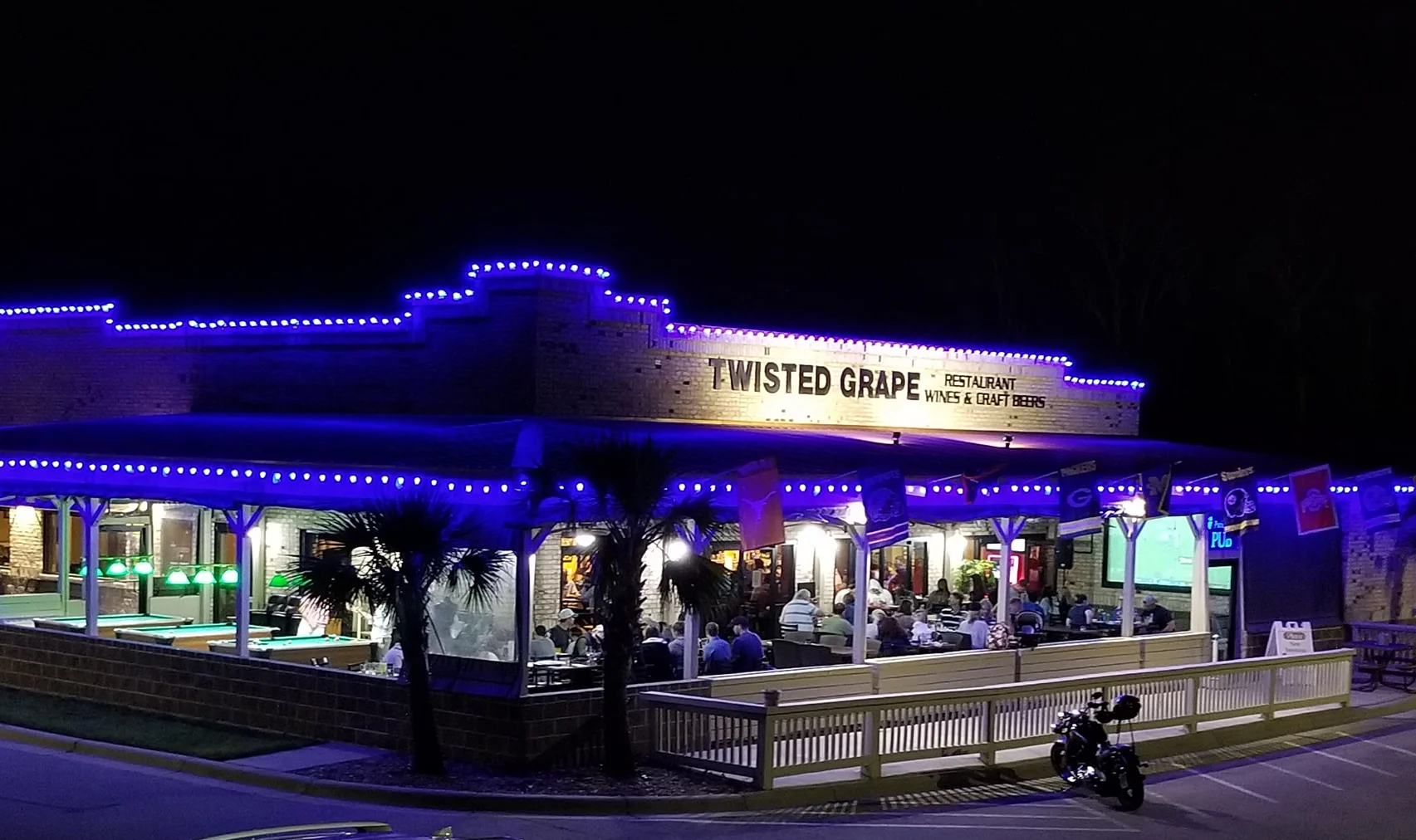 Twisted Grape restaurant illuminated at night with outdoor seating