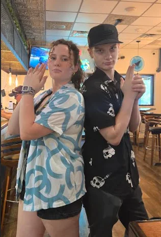 Two friends posing playfully in a restaurant setting