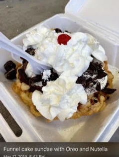 Decadent funnel cake sundae topped with whipped cream