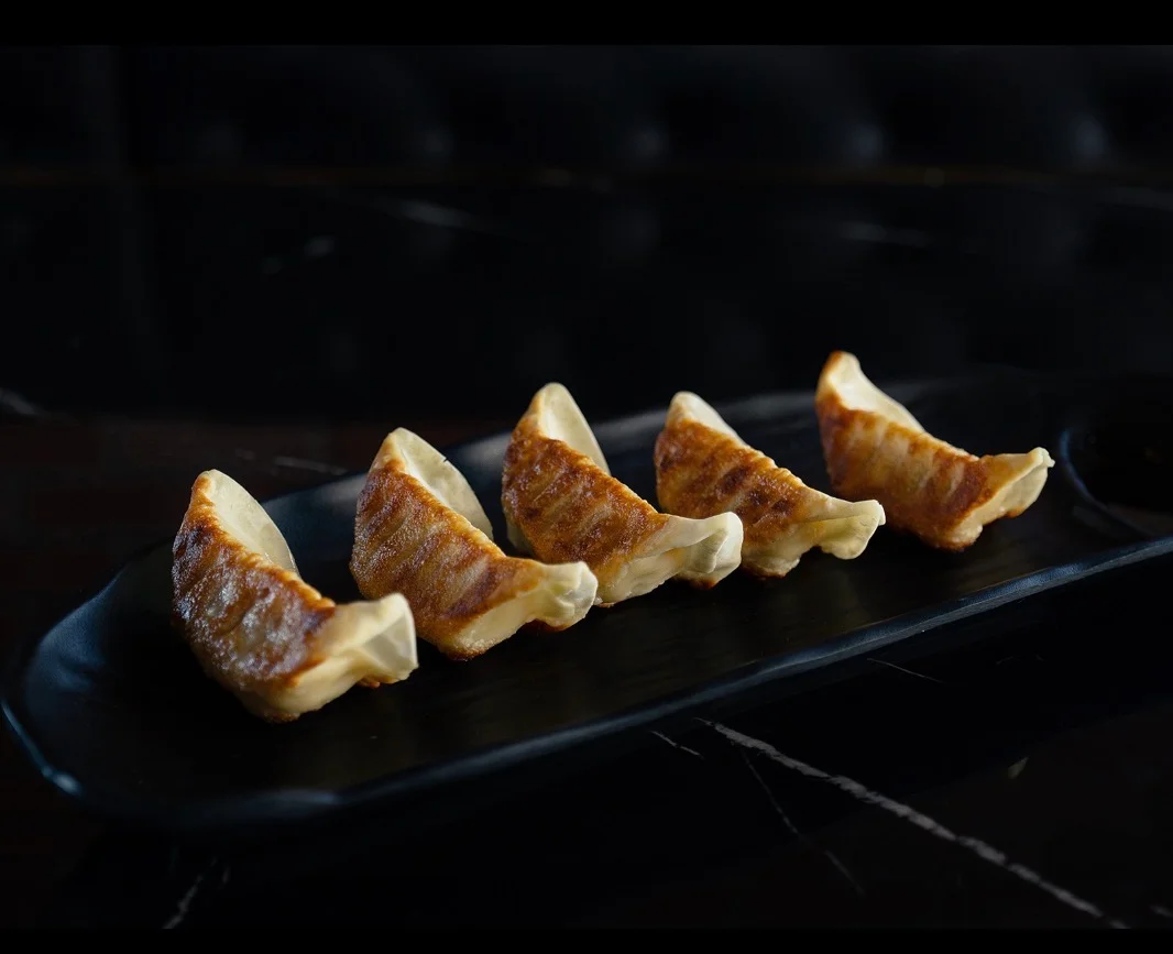 Japanese gyoza dumplings arranged on a black plate
