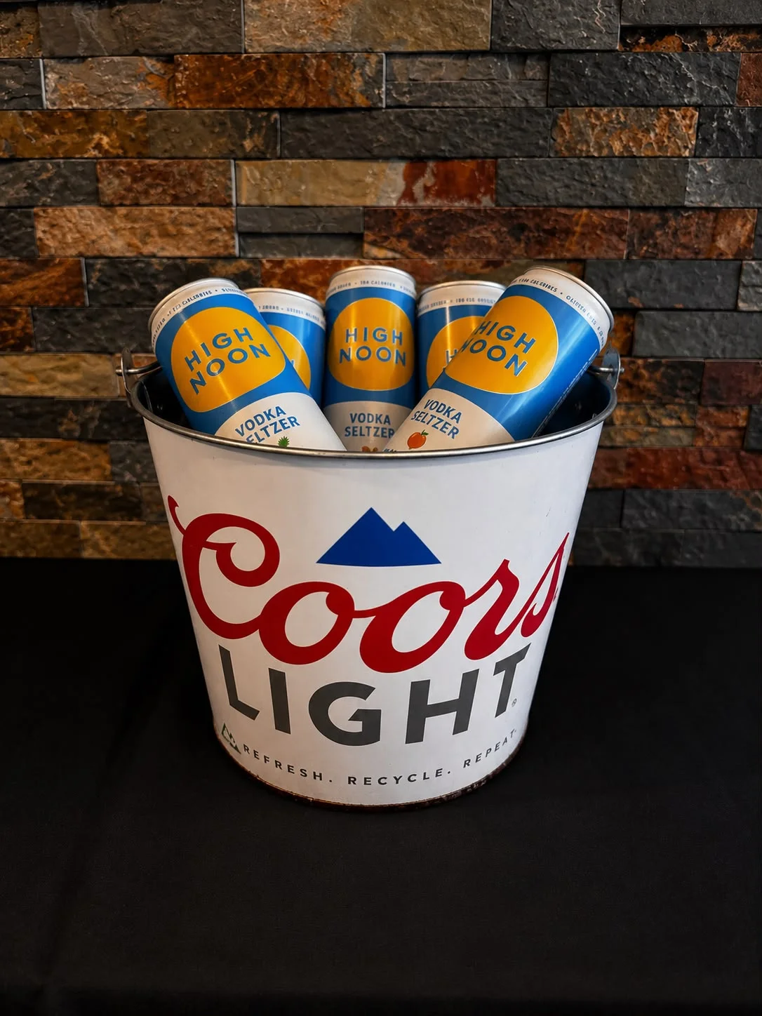 Chilled High Noon vodka seltzers in a Coors Light bucket