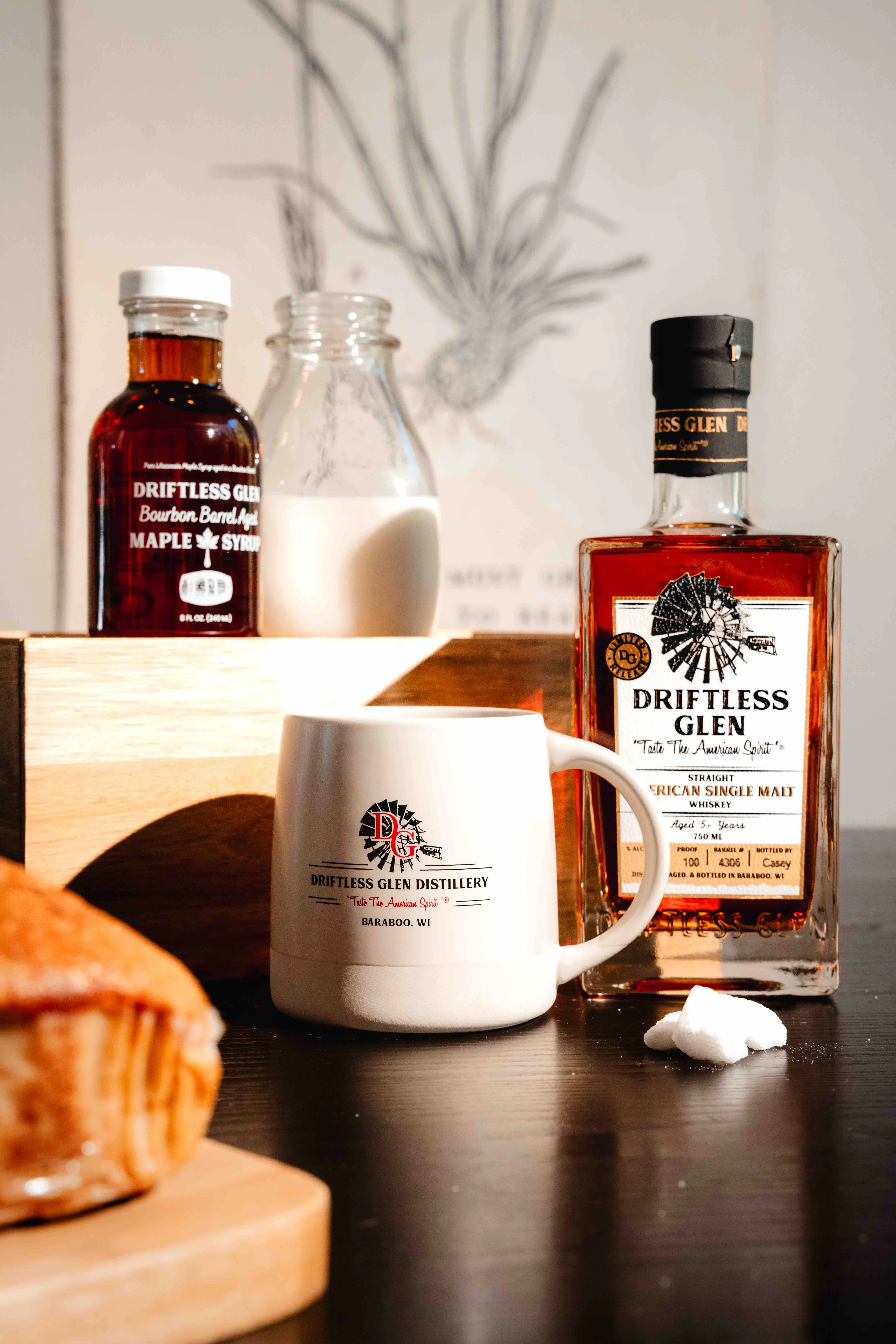 A cream coffee mug with some sugar and syrup and single malt