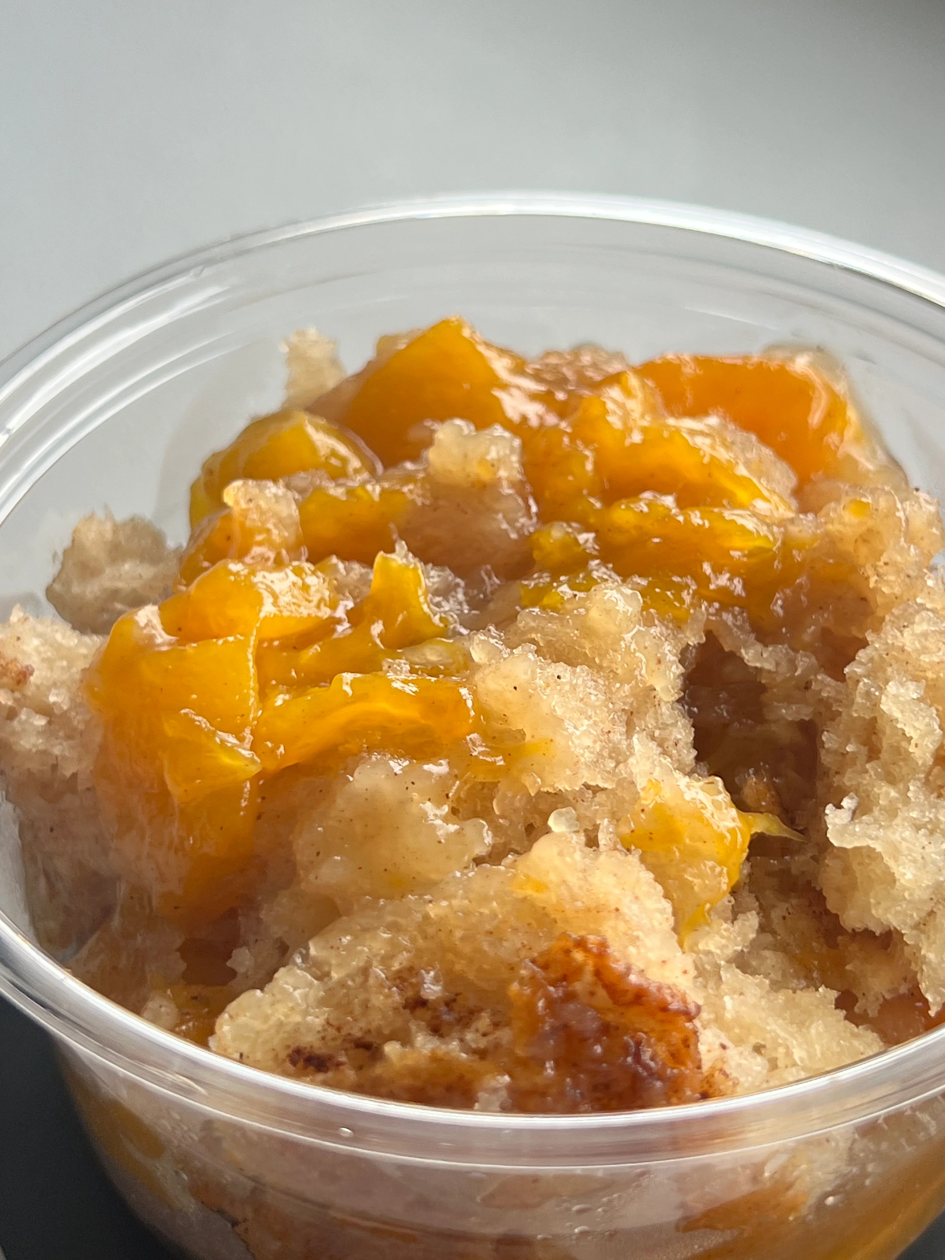 Peach cobbler dessert in a clear cup
