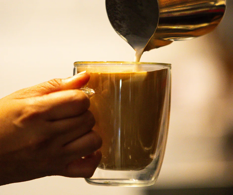 Pouring creamy Vietnamese coffee into a glass mug